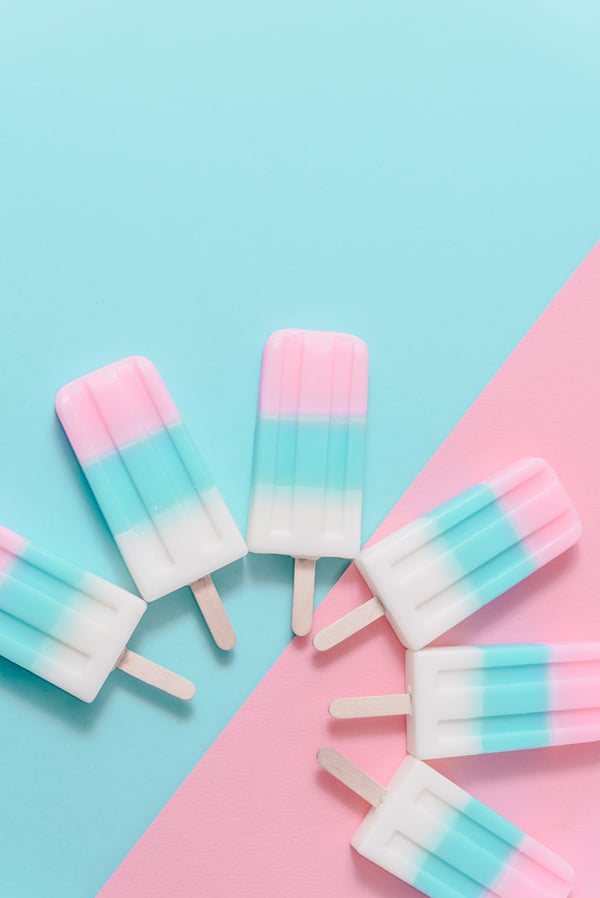 Pastel-colored-ice-cream-pops-on-pastel-pink-and-blue-background