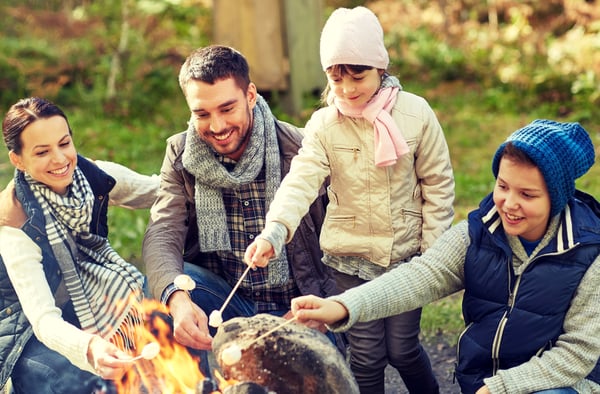 Happy-family-of-four-roasting-marshmallows-over-an-outdoor-fire