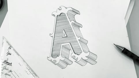 A graphic designer sketches a logo of an A, to be later paired with royalty free logo animation background music and sound effects to enhance the logo’s impact.