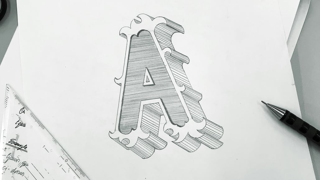A graphic designer sketches a logo of an A, to be later paired with royalty free logo animation background music and sound effects to enhance the logo’s impact.