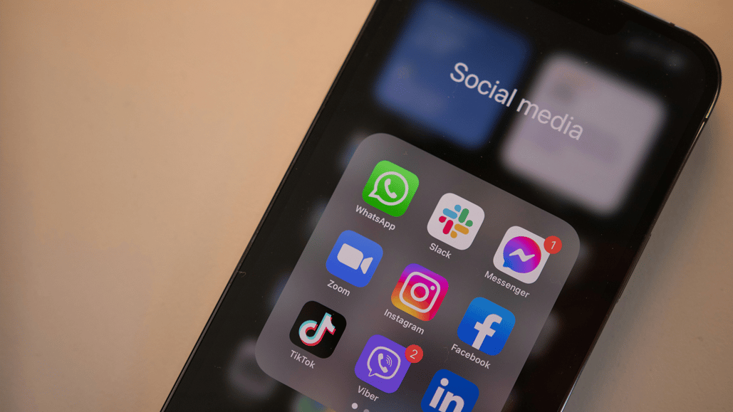 A phone displays multiple social media apps, as a content creator learns about multi platform posting, and develops a cross platform content strategy
