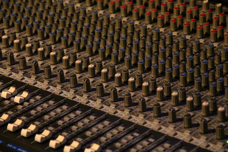 A sound engineer compares 48khz vs 44.1 khz sample rates for a recording on a detailed sound board.