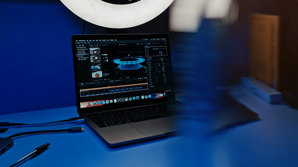 A laptop sits beneath a ring light, with Final Cut music editing software open, ready to edit a project using royalty free music for Final Cut Pro.