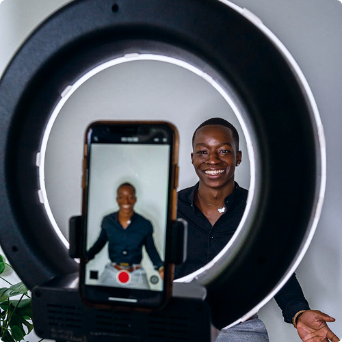 Content creator using a ring light while filming for social channels