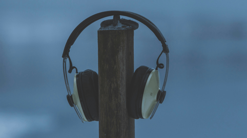 Black and silver wireless headphones sit on a stand ready to be used for listening to 3D immersive audio