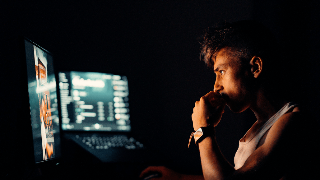  A man sits in in front of his computer, intently watching a podcast that explores the topic, ‘What is Meta Vibes?’